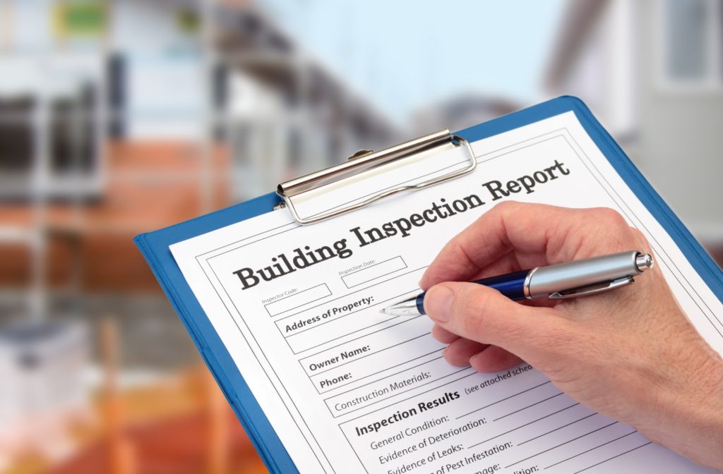 A close up of somebody ready to fill out a building inspection report for someone preparing to buy a home