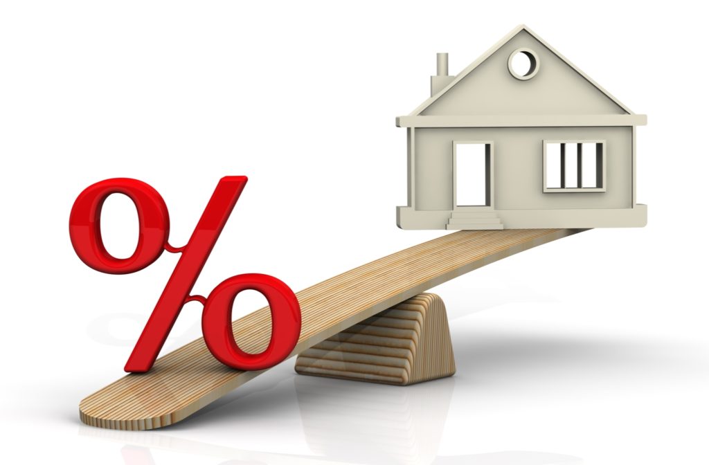 A seesaw with a cartoon home on one end and a percentage sign on the heavier side illustrating a higher percentage of a downpayment on a home