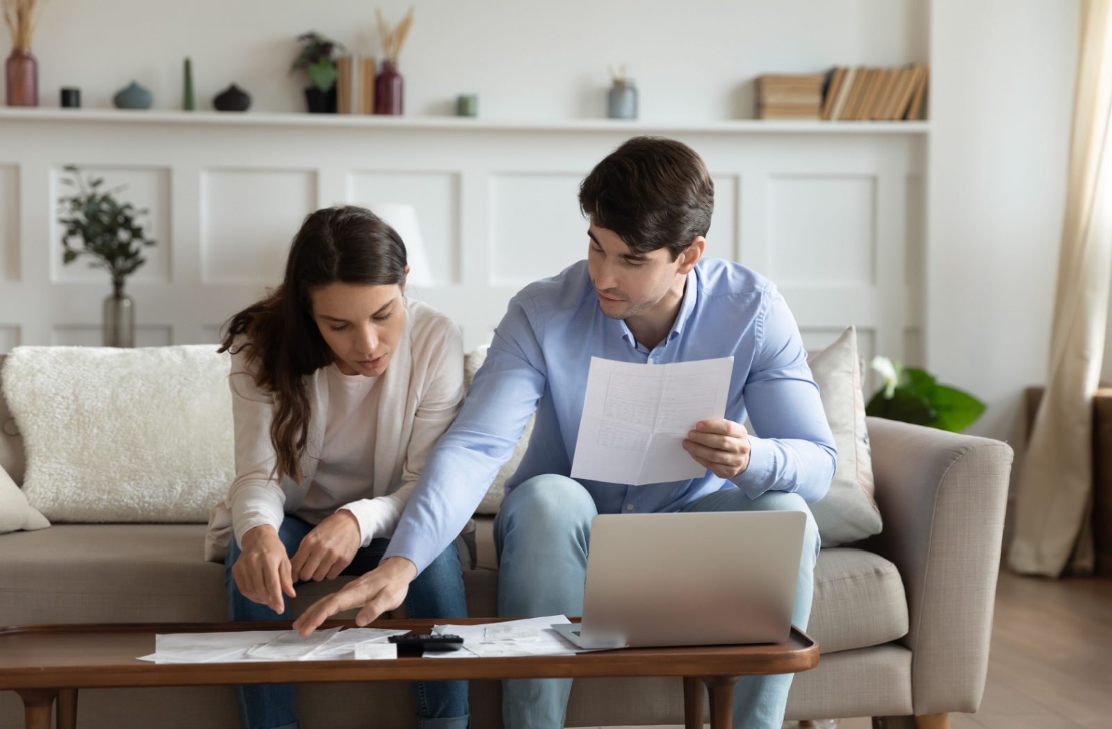 Couple reviewing mortgage renewal documents together at home with a laptop.