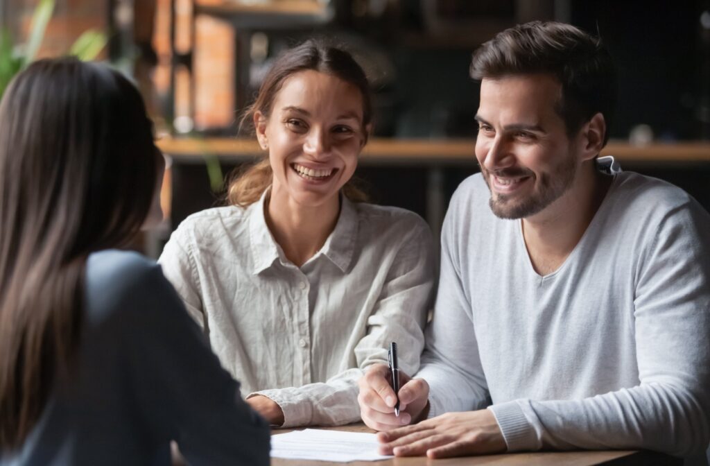 Smiling couple meeting with a mortgage advisor to discuss renewal options.