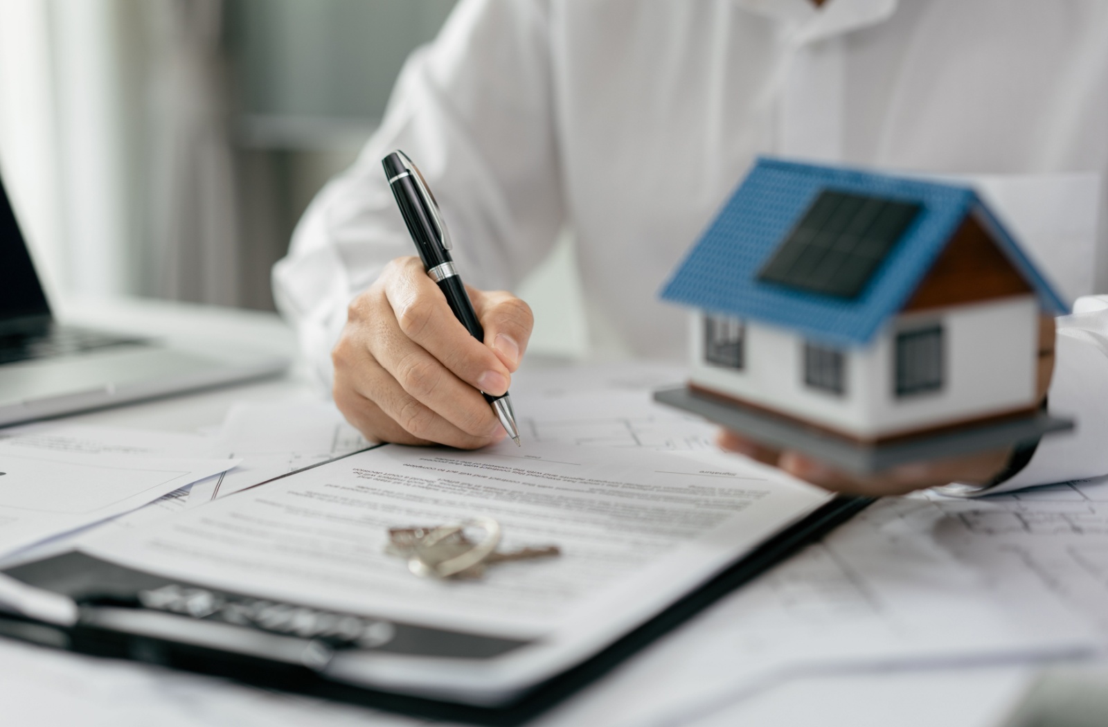 A mortgage broker writing on a mortgage agreement.