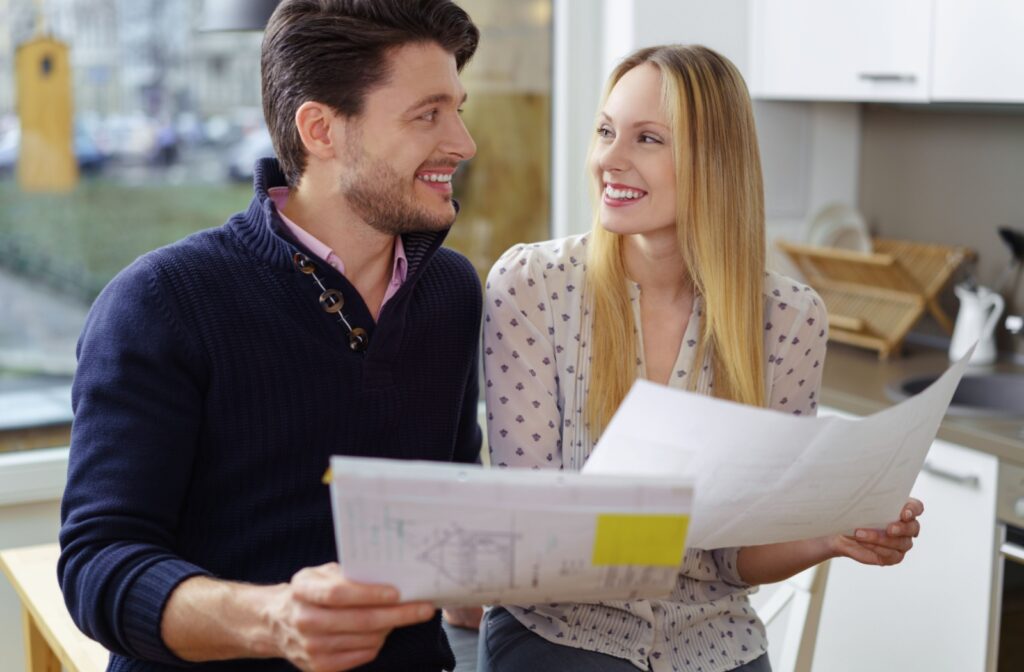 A couple looking at each other while reviewing their mortgage renewal papers.
