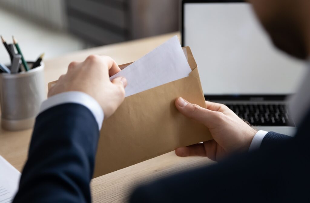 A mortgage broker pulling out a gift letter from an envelope.